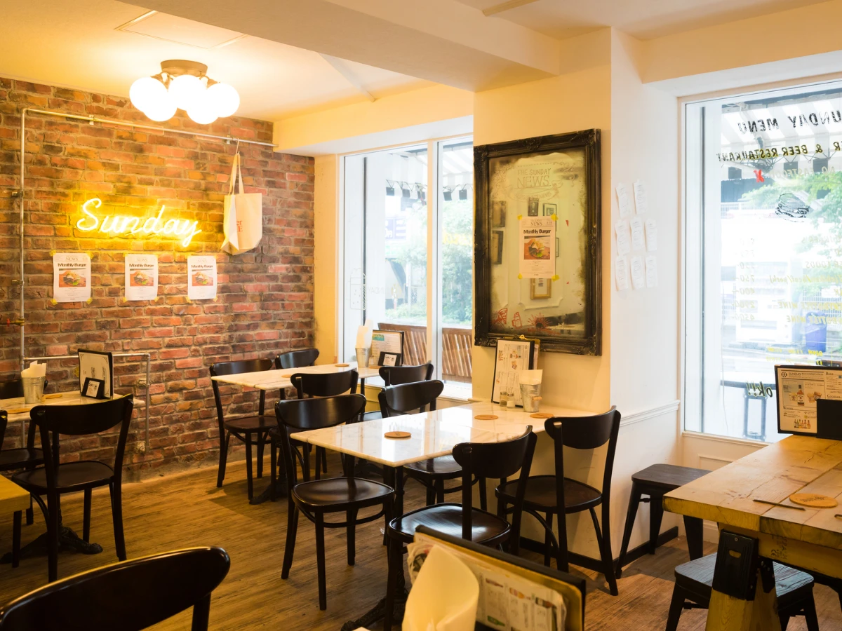 レンガ壁とネオンサインが特徴的な、温かみのあるカフェの店内風景