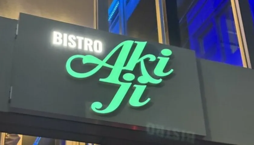 「BISTRO Akiji」のネオン看板。緑色の鮮やかなライトアップ