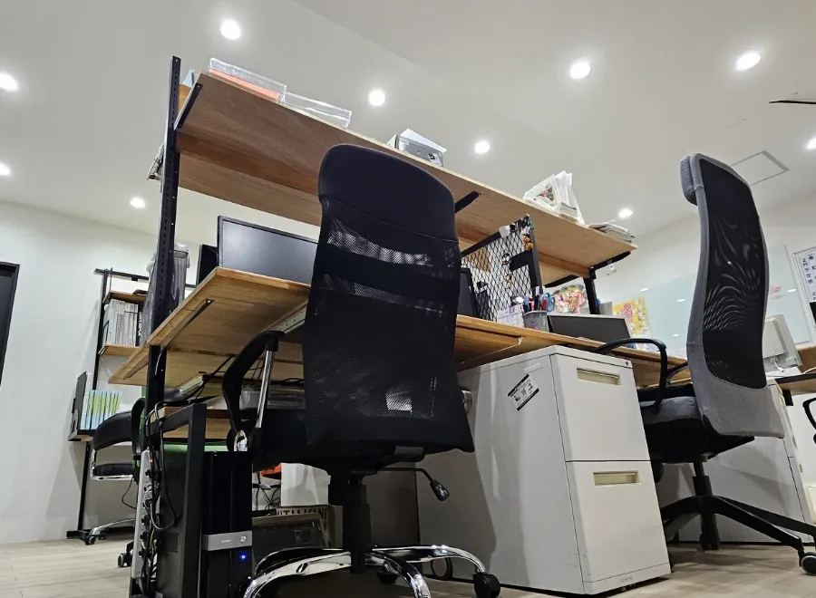 デスクとメッシュチェアが並ぶ清潔感のあるオフィス執務室