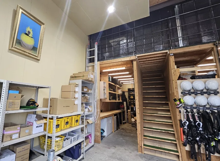 ヘルメットや工具が整理された倉庫内の作業・収納スペース