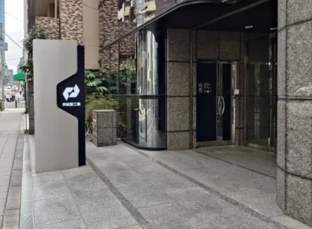 「林純薬工業」の看板が設置された、石造りの重厚なビルのエントランス外観