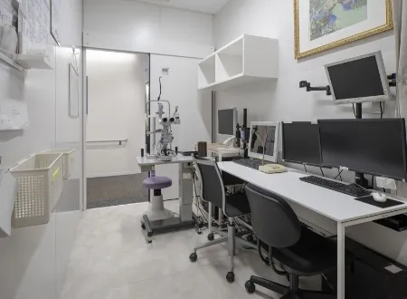 複数のモニターと検査機器が設置された、白く清潔な臨床検査室または診察室